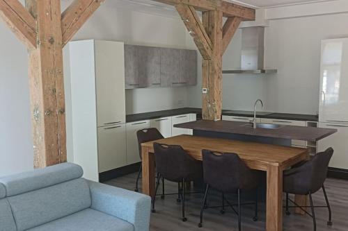 une cuisine avec une table, des chaises et un canapé bleu dans l'établissement Golfbaan om de hoek!, à Nieuwveen