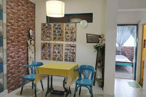 a dining room with a yellow table and blue chairs at Comfy Home Near to Penang Hill in Ayer Itam