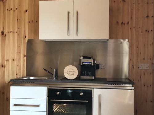 a kitchen with a stove and a microwave at Neadín Beag in Tralee