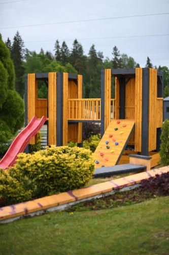 um parque infantil com escorrega e uma prancha de escalada em Jolanta em Alūksne