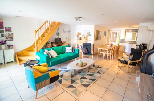 a living room with a green couch and a table at L'amigeste in Pouzols-Minervois