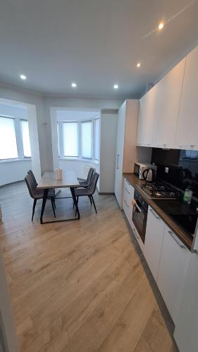 a kitchen with a table and chairs in a room at Аэропорт Апартаменты 24&24 Parking in Chişinău
