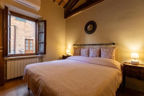 a bedroom with a large bed and a window at La Corte del Podestà in Sarteano