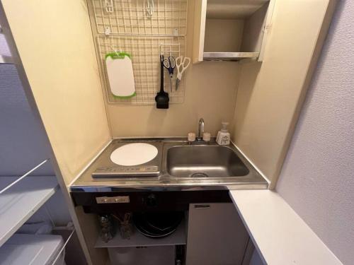 Il comprend une petite cuisine avec un évier et un comptoir. dans l'établissement Cozy inn Oyama, à Tokyo