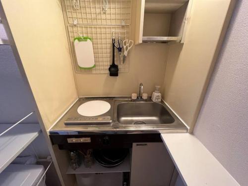 a small kitchen with a sink and a counter top at Cozy inn Oyama in Tokyo