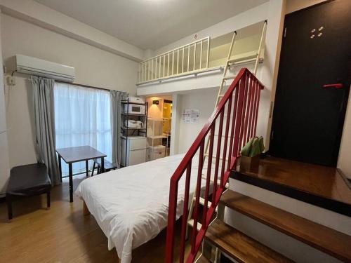 - une chambre avec un lit et un escalier dans l'établissement Cozy inn Oyama, à Tokyo