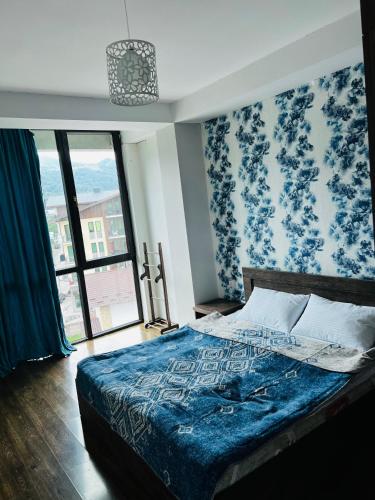 a bedroom with a bed with blue floral wallpaper at BOBLINE BAKURIANI SUITE in Bakuriani