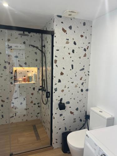 a bathroom with a shower with a rock wall at Apartamento la roca (Bajondillo) in Torremolinos