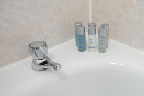 Un mostrador de baño con tres botellas de odorizantes. en Premier Apt - Bridge View-Rosyth, en Rosyth