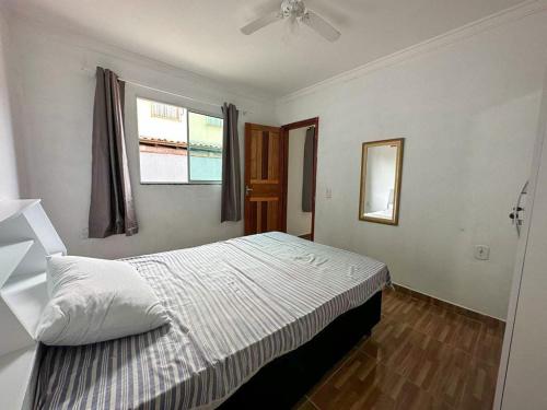 a bedroom with a bed and a window at Casa toda - Praia Barra do Sahy - Aracruz in Aracruz