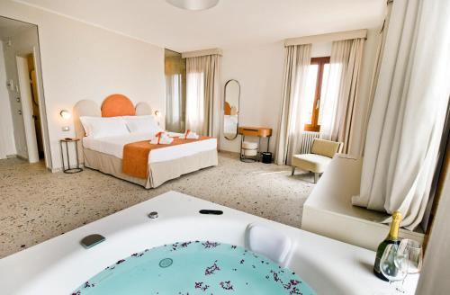 Maison Boutique Al Redentore في البندقية: غرفة في الفندق مع سرير وحوض استحمام