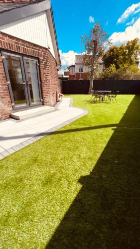 a grassy yard with a building and a picnic table at Cozy Charming Bungalow BRAND NEW in Preston