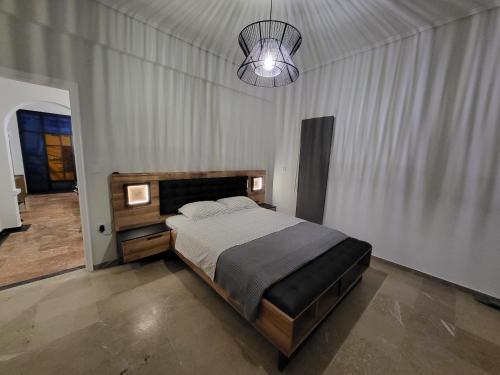 1 dormitorio con cama y lámpara de araña en Dilion Guest House, en Dhílesi