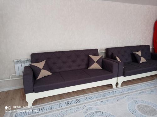 a blue couch with pillows in a living room at Save Haven Karakol in Karakol