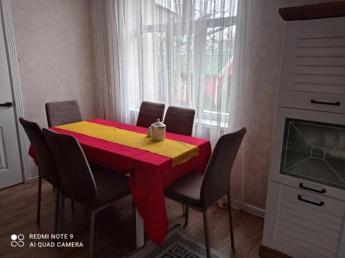 a dining room table with a red and yellow table cloth at Save Haven Karakol in Karakol