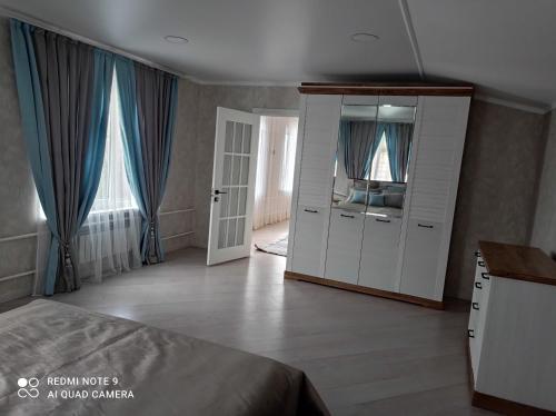 a bedroom with a bed and a dresser and a mirror at Save Haven Karakol in Karakol