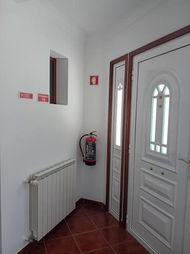 a hallway with a white door and a window at PESO RIVER HOUSE in Melgaço