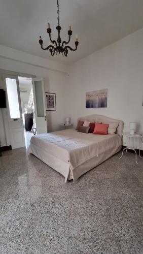 een grote slaapkamer met een groot bed en een kroonluchter bij Le Dimore del Corso I ad Acireale fra Catania, Taormina, il Mare e l'Etna in Acireale