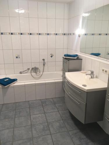 a bathroom with a bath tub and a sink at Schöne Gartenwohnung im Seenland in Wackersdorf