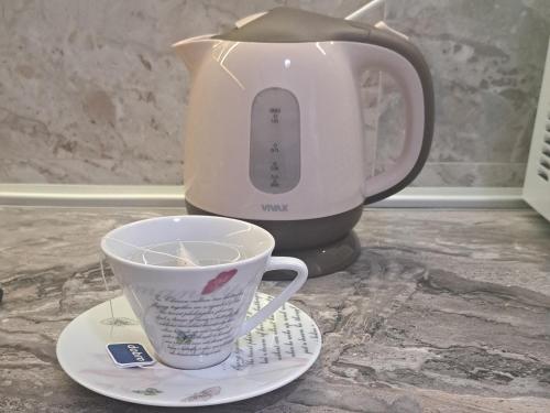a coffee maker and a cup on a table at Apartman Miss T in Podgorica