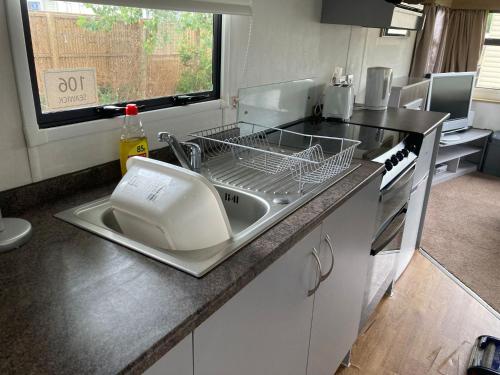 a kitchen with a sink and a dish rack at Dotty at Seawick 106 in Jaywick Sands