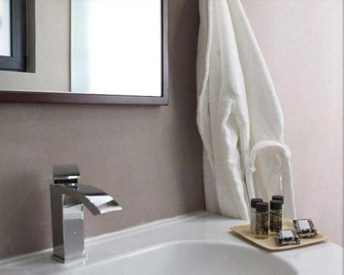 a bathroom sink with a mirror and a towel at Natura Hotel Vytina in Vitina