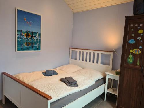 a bedroom with a bed with a picture on the wall at Haus Freija in Sehestedt
