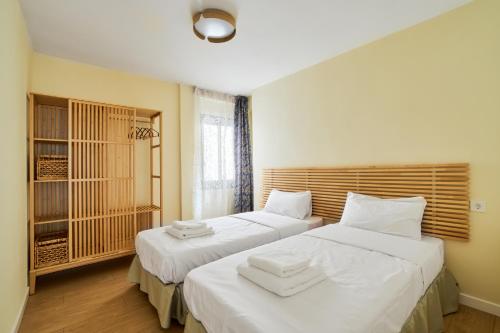1 dormitorio con 2 camas con sábanas blancas en Casa Ola, en Salou