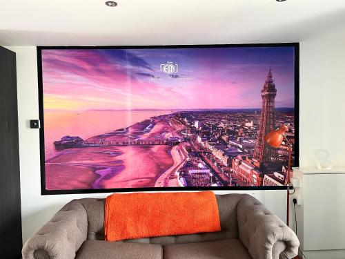 a large screen tv in a living room with a couch at Tower Suite Serviced Apartment Blackpool in Blackpool