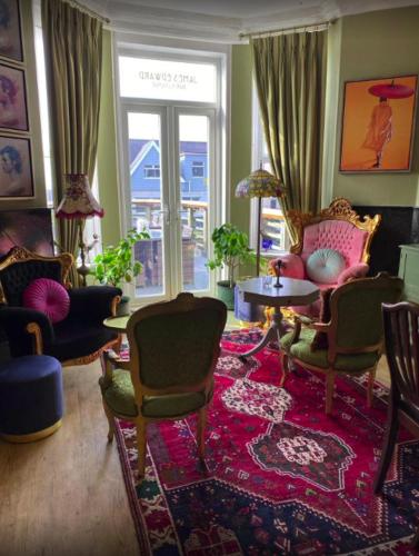 a living room with chairs and a red rug at The White House Hotel in Newquay