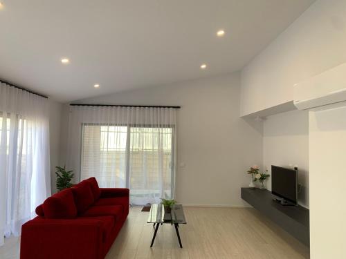 ein Wohnzimmer mit einem roten Sofa und einem TV in der Unterkunft Sun and Sea Holiday Home in Cowes
