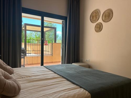 1 dormitorio con cama y vistas a un balcón en Quite & relaxing private apartment for 2-6 pers - Golf & Pool resort - Murcia, en Murcia