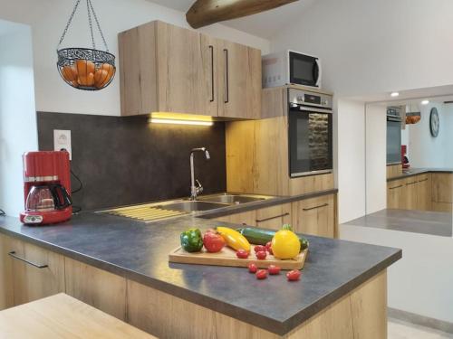 une cuisine avec une table de découpe avec des légumes sur un comptoir dans l'établissement Escapade entre terre et mer, à Melgven