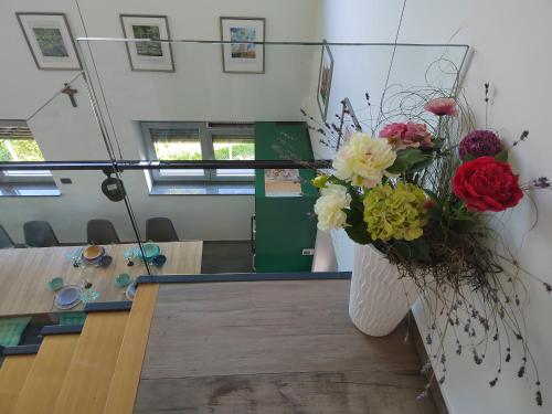 a vase of flowers on a table in an office at Ob Potoku 