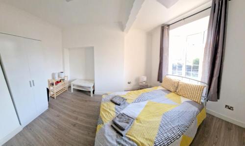 een slaapkamer met een bed en een groot raam bij Lilleshall Rooms in Mitcham