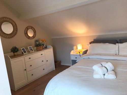 a bedroom with a white bed with towels on it at J&S Downtown Sky Attic House in Belfast