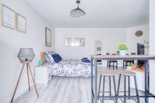 Cette chambre comprend un lit, une table et des tabourets. dans l'établissement LOGEMENT ABEL Classé 1 étoile, Évry-Courcouronnes