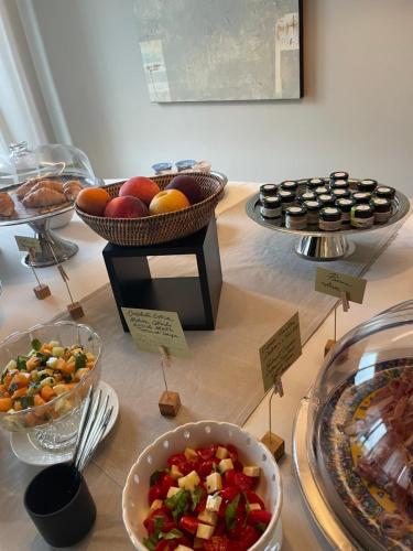 a table with plates of food and bowls of fruit at iCOLLIROSSI Agriturismo in Monforte dʼAlba