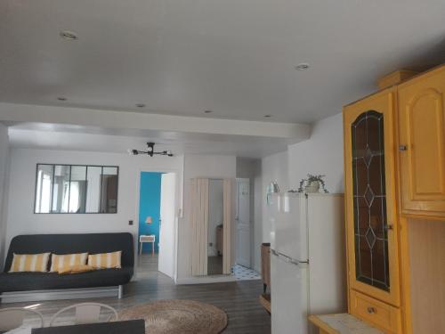 - un salon avec un canapé et un réfrigérateur dans l'établissement La Petite Maison Près de Paris, à Saint-Michel-sur-Orge