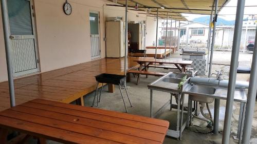 eine Küche mit Holztischen und -bänken und einer Spüle in der Unterkunft 돼지민박 102호 진하해수욕장 in Ulsan