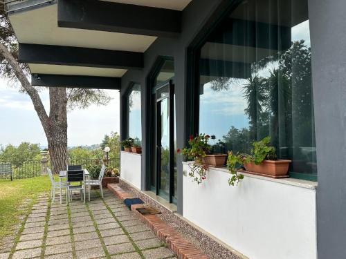 uma casa com um pátio com uma mesa e janelas em Villa Roccia Scura dell'Etna em Zafferana Etnea