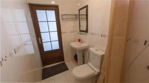 a bathroom with a toilet and a sink and a mirror at Résidence Le Palmier in Mont Choisy