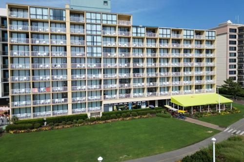 a large building with a green lawn in front of it at Four Points by Sheraton Virginia Beach Oceanfront in Virginia Beach