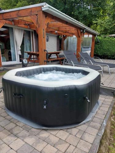 a large hot tub sitting on a patio at chalet avec jacuzzi in Manhay