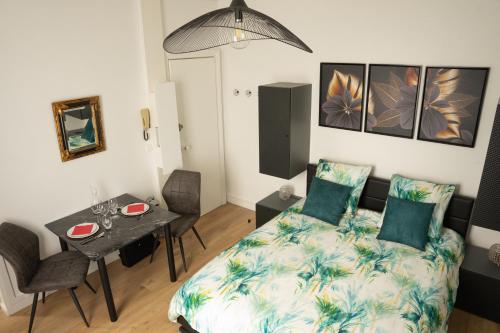 a small bedroom with a bed and a table at Le confort à 2 pas de la gare in Sens