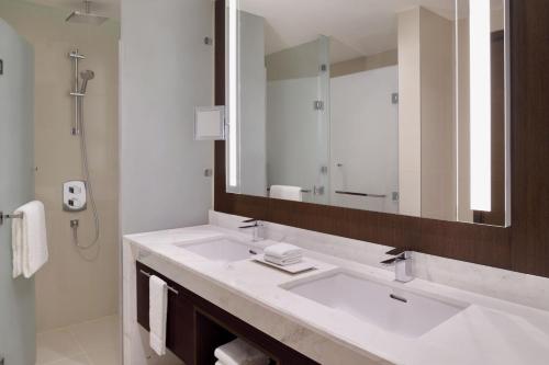 a bathroom with a sink and a large mirror at Delta Hotels by Marriott City Center Doha in Doha
