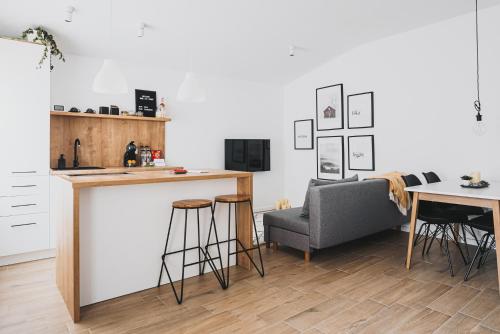 a kitchen with a bar and a chair and a table at VOYA NORDIC Apartment-a luxury oasis in the old town in Braşov