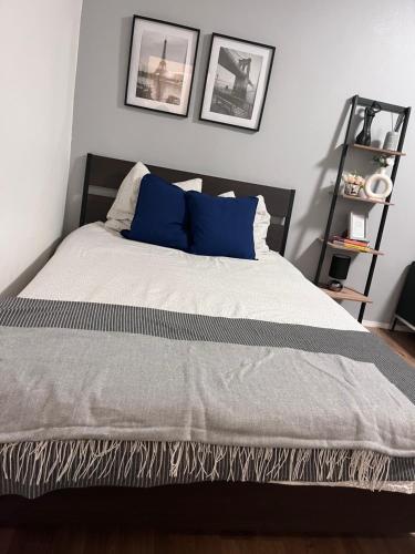 - un lit avec des oreillers bleus dans une chambre dans l'établissement Commerce à proximité et 10 minute de la gare, à Noisy-le-Sec