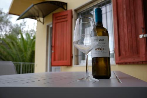 una botella de vino junto a una copa de vino en Villa Anna Bolgheri, en Bolgheri