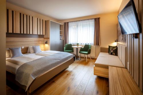 a hotel room with a bed and a table at JUFA Hotel Malbun in Malbun